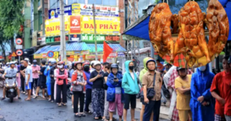 Người dân TP.HCM đội mưa xếp hàng dài mua heo quay, vịt quay cúng Thần tài