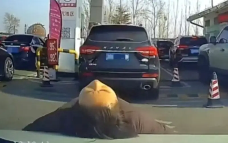 Người phụ nữ nằm lên capo xe để chen hàng đổ xăng gây tranh cãi ở Trung Quốc