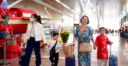 Hành khách mặc áo dài, ôm hoa mai rộn ràng lên chuyến bay đầu năm mới