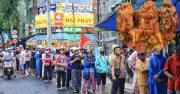 Người dân TP.HCM đội mưa xếp hàng dài mua heo quay, vịt quay cúng Thần tài
