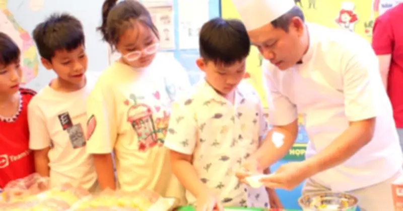 Học sinh xếp hàng làm bánh dân gian cùng thầy hiệu trưởng tại ngày hội văn hóa Việt