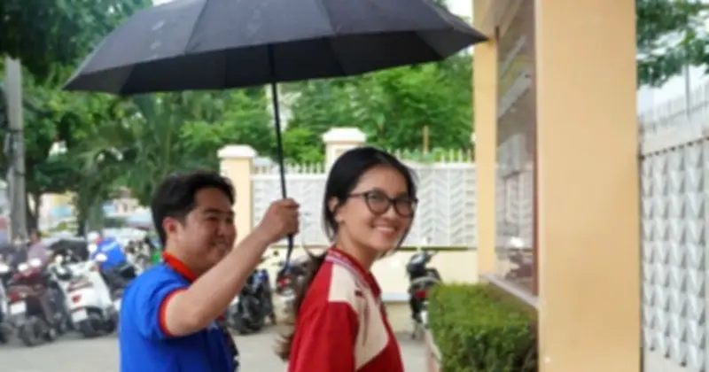 Áo xanh tình nguyện che mưa tiếp sức thí sinh làm thủ tục thi tốt nghiệp THPT