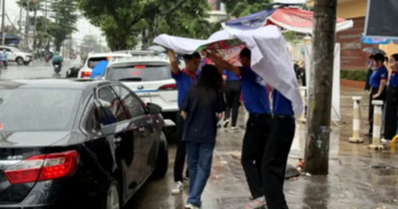 Tình nguyện viên tiếp sức mùa thi che mưa cho thí sinh
