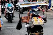 Người phụ nữ trên xe lăn tự chế rong ruổi bán vé số